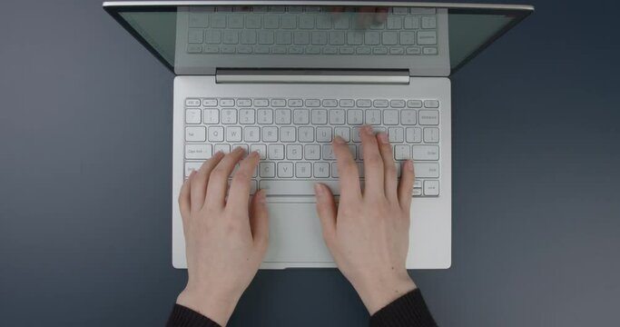 Close-up. Office table. Hands of a girl working on a laptop. Flat lay
