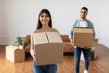 Happy man and woman holding cardboard boxes, relocation concept