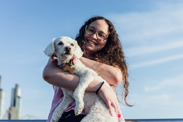 young white latina girl happy holding her poodle dog after going to the vet for annual vaccinations