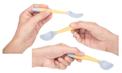 Collection of hand holding Bendable kids training Spoon Fork Set isolated on white background.