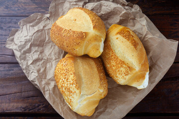 Brazilian French bread, on rustic paper, on rustic wooden table for breakfast