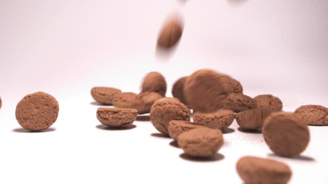 Single pepernoten falling in slow motion. White background.