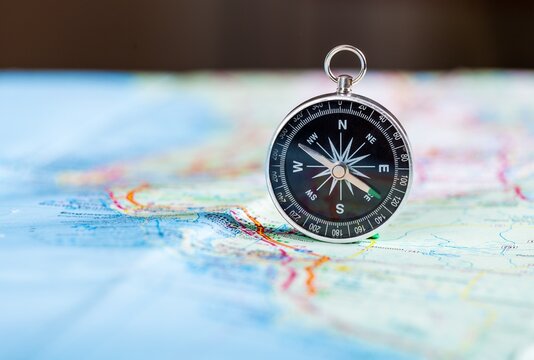 compass on the map and book in the background in the area of confusion