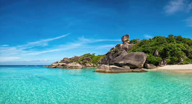 Tropical islands of ocean blue sea water and white sand beach at Similan Islands with famous Sail Rock, Phang Nga Thailand nature landscape panorama