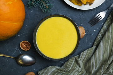 Bowl of pumpkin cream soup with walnuts. Healthy vegetarian food. Thanksgiving day food concept, top view.