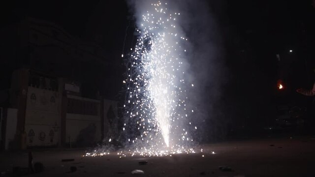 Slow motion shot of the flower pot firecracker burning during the Diwali festival in India. Diwali festival background, People enjoying the Diwali festival by burning firecrackers