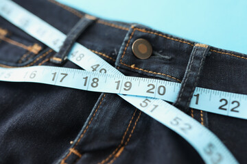 Denim trousers or jeans with blue measure tape around waist