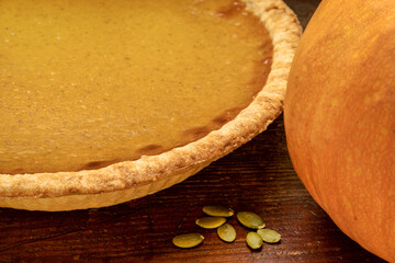pumpkin pie and pumpkin on a rustic wooden table, Thanksgiving and fall holidays concept