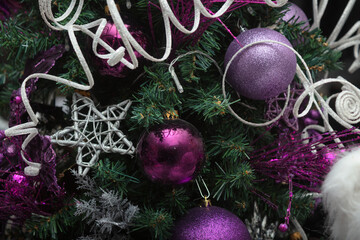 purple christmas tree with star and baubles ornaments close-up fir decorations