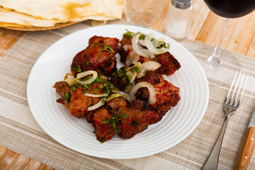 Popular russian dish shashlik, barbecued pork meat served with onion and herbs