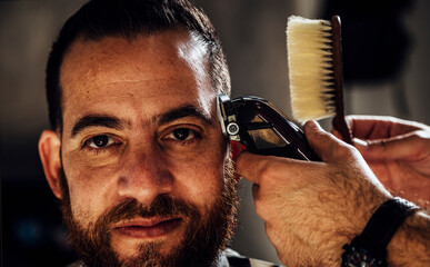 Closeup of trimmer machine. Process of trimming of hair in barber shop.