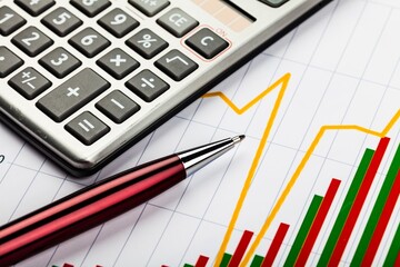 Calculator and Pen on Business Graphs