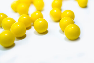 yellow round pills vitamins bada on white table close up