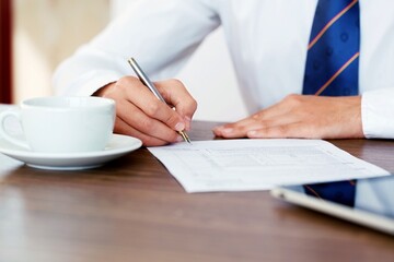 Businessman signing contract on the office desk.