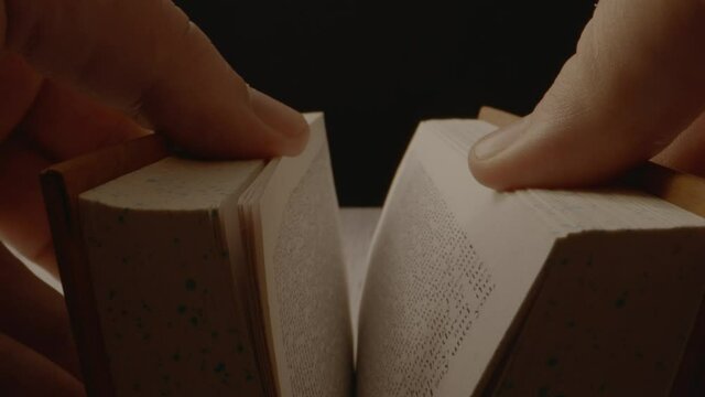 slowly opening of an old book with a slow push in on the book.