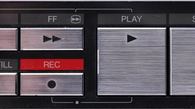 Extreme close up of buttons on an old antique or vintage VCR Pushing the Play button