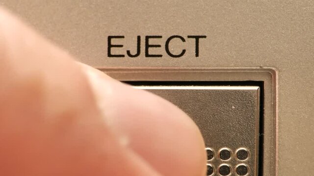 Extreme close up of buttons on an old antique or vintage VCR pushing the eject button