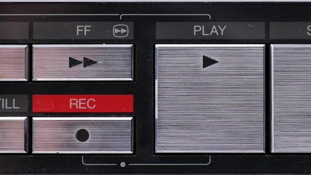 Extreme close up of buttons on an old antique or vintage VCR Pushing the Record button