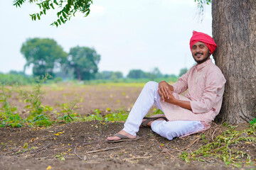 Naklejka na ściany i meble Young indian farmer sitting at agriculture field.