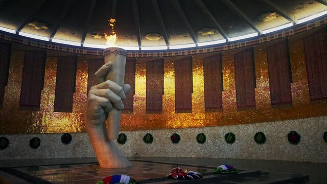 A sculpture of a hand with an eternal flame in the pantheon of glory on Mamayev Kurgan