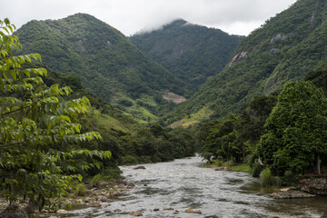 Fototapeta na wymiar View of nature in Sana, Macaé, mountainous region of Rio de Janeiro. Photo of the river with mountains around at the entrance to the city