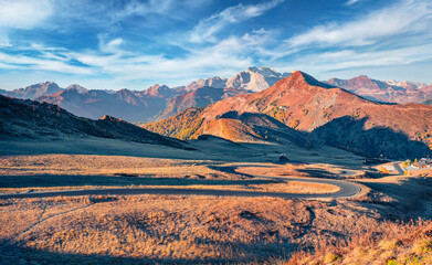 Fototapeta premium Spectacular autumn view of winding road in Dolomite Alps. Stunning landscape of Giau pass, province of Belluno in Italy. Fantastic morning scene of mountain valley. Traveling concept background.