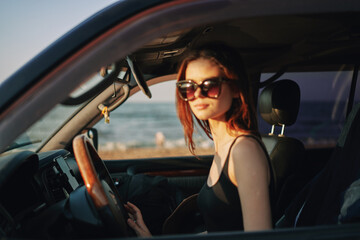 Fototapeta na wymiar cheerful woman in sunglasses driving a car trip travel