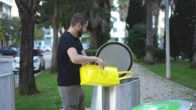 People dispose of sorted garbage by waste separation. Plastic bag, package disposing in recycling bin, can. Eco friendly trash segregation management. Young adult bearded man preserving planet ecology