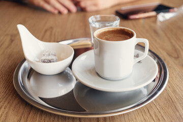 Traditional Turkish coffee with cold water and Turkish delight in cafe. Selective focus