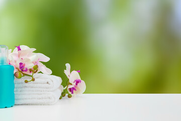 Towels with flowers on light table against blurred background