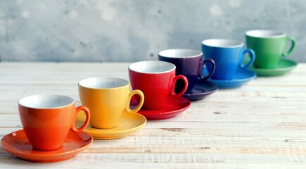 Obraz na płótnie Canvas Bright multi colored tea cups cheer you up. Porcelain kitchen utensils.