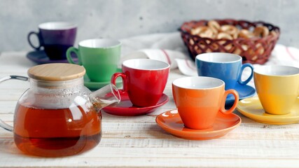 Bright multi colored tea cups cheer you up. Porcelain kitchen utensils.