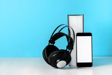 Headphones on book empty phone screen. Audiobook horizontal banner copyspace. Online education and e-learning concept