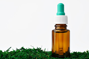 Bottle of aromatic oil for herbal medicine among natural green moss