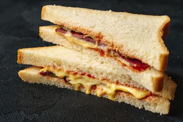 Sandwiches with ham, cheese on dark gray background