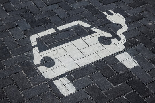 ein Elektroauto an einer Ladestation wird aufgeladen - Symbolzeichen