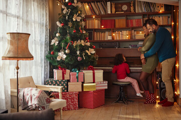 Obraz na płótnie Canvas Parents enjoying holidays with daughter at home