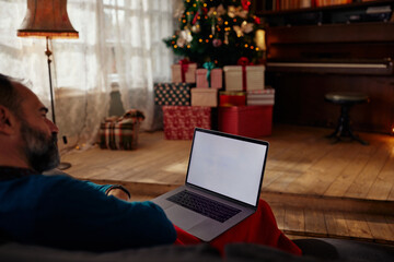 Middle age using laptop Christmas evening at home.