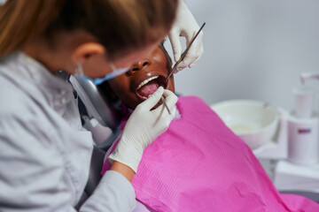 Female dentist and african patient in a dentist office
