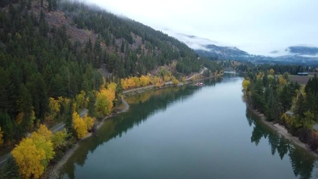 A ferry crosses a river in British Columbia on a foggy, autumn day