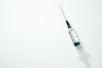 Medical syringe and needle with medicament on a light background