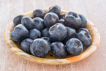 Blueberries in a bowl on a wooden table.