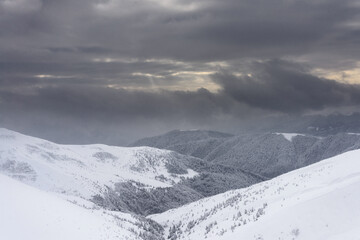 Obraz premium Mountains in winter. Snow-covered mountain slopes at sunset.