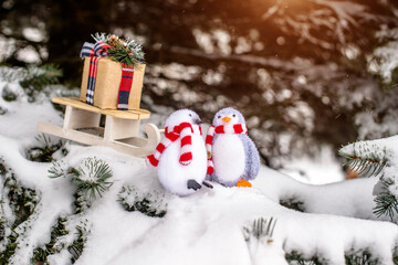 Christmas background-penguins carry a gift on a sled
