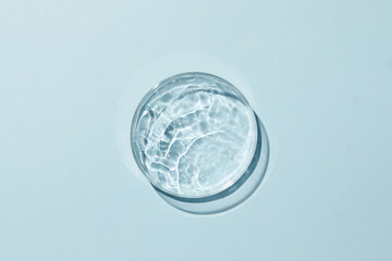 Petri dish with water and ripple in blue background