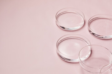 Petri dishes with water and ripple in light pink background for skincare