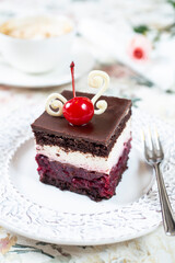 Chocolate cake with whipped cream and cherries on top