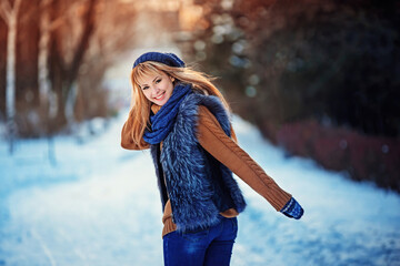 Fototapeta na wymiar Beautiful happy smiling girl wearing sweater, knitted hat and gloves. Young woman feeling happy and positive. Lifestyle expression emotions concept and Christmas holiday. Enjoying winter weather.