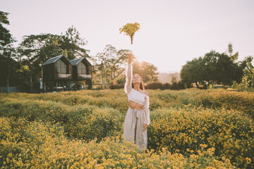 Young attractive woman having fun in yellow flower field