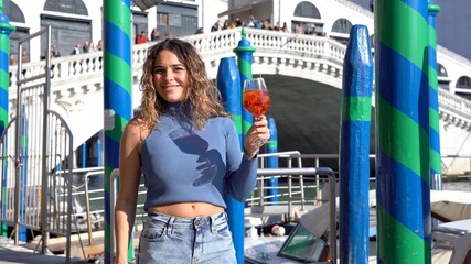 Girl holds in hand and drinks a glass of Spritz, in the city of love - aperitif, alcoholic drink...